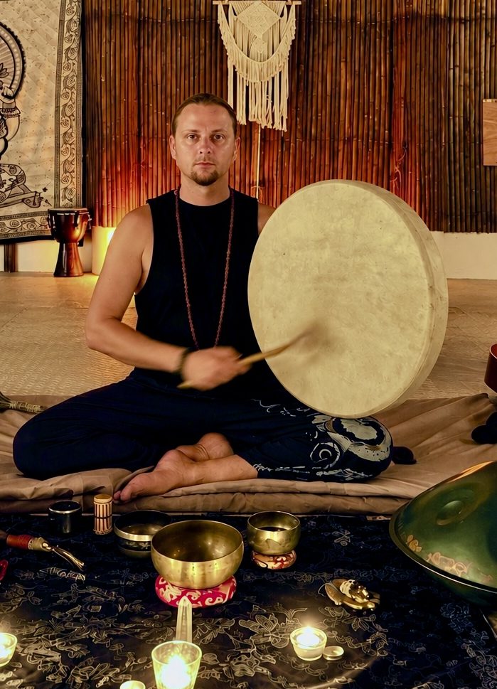 Yakov Rajuna sitting with a frame drum